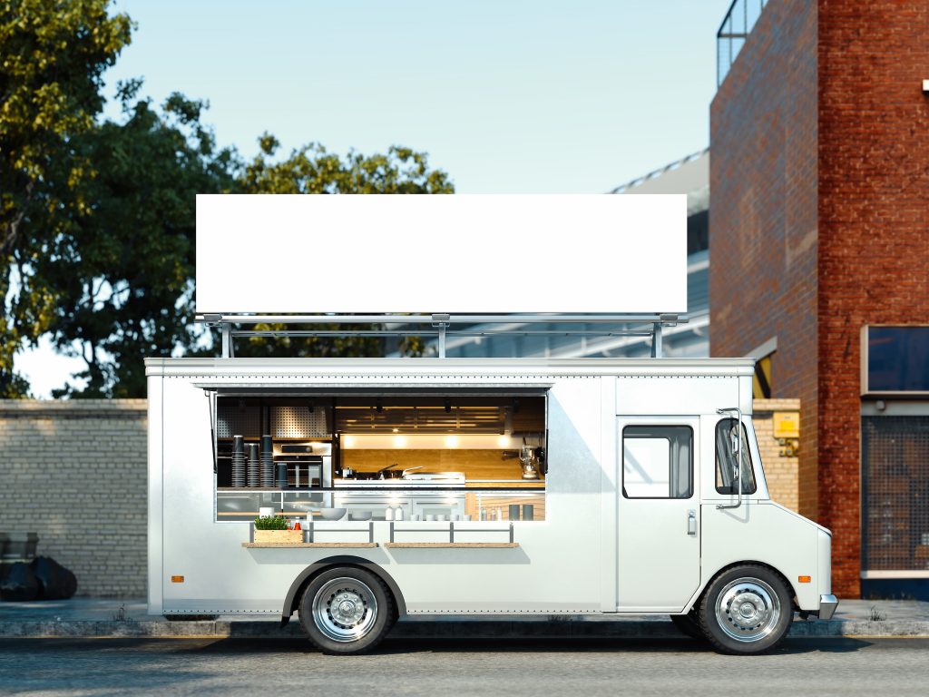 A white and clean food truck living it's best life in the center of the frame.er